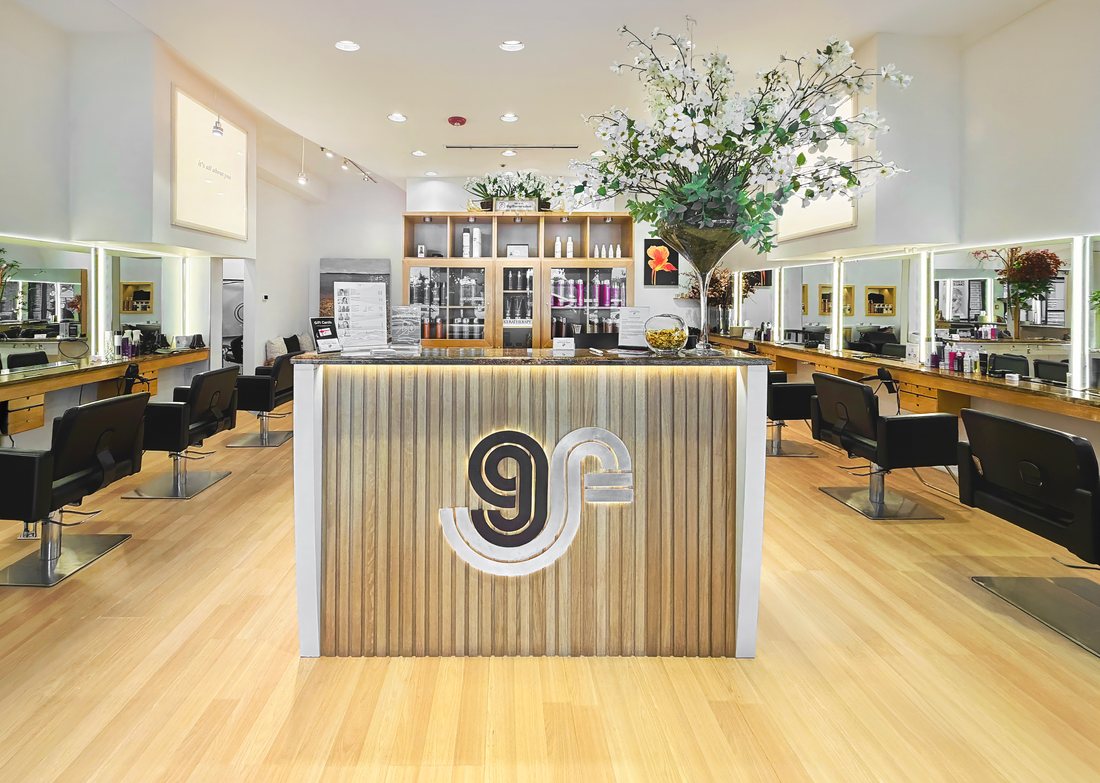The front desk at Gil Ferrer Salon, Bridgehampton Commons, with styling stations down both sides of the room